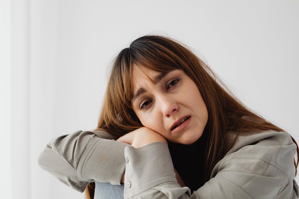 Close-up of a woman expressing sadness and emotional distress indoors.
