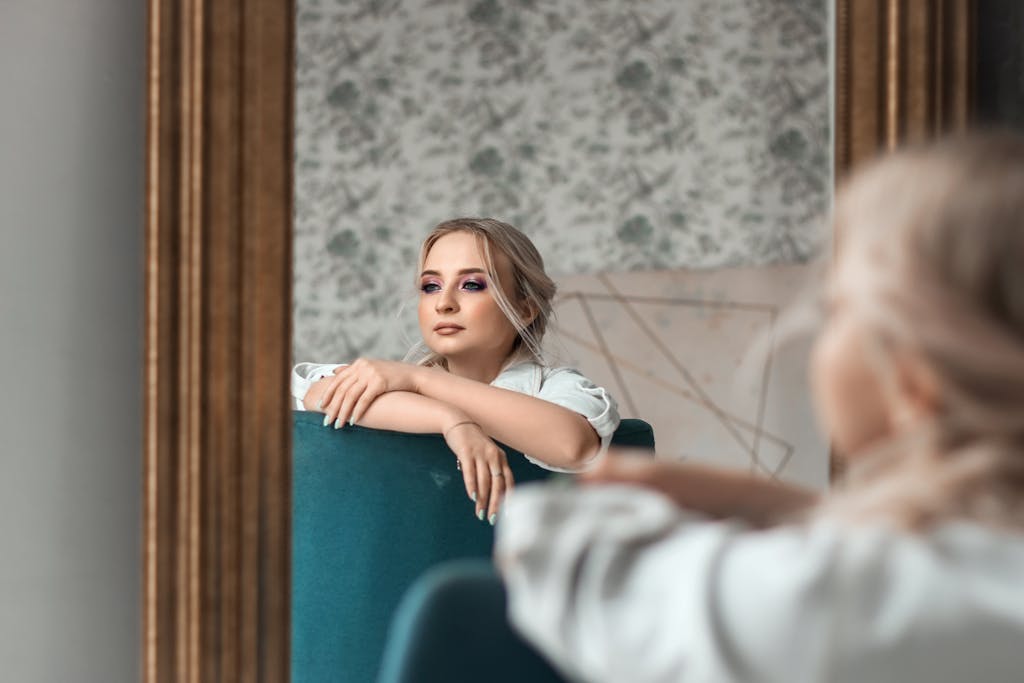Elegant woman gazing into a mirror, creating a thoughtful and stylish composition.