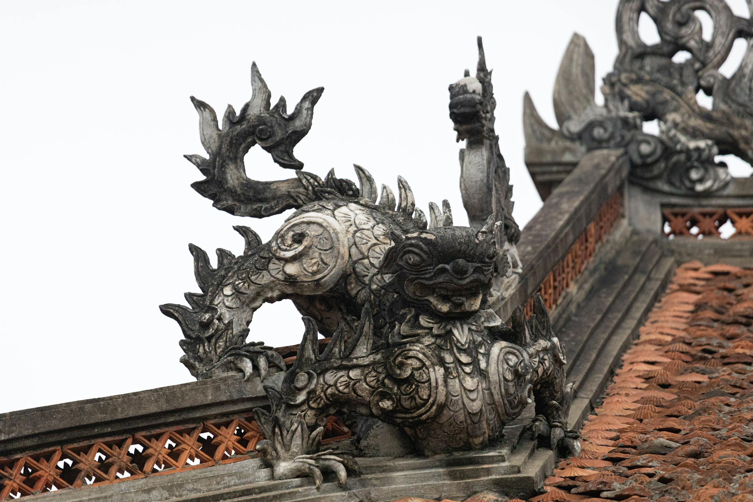Intricate dragon sculpture atop a traditional rooftop in Hà Nội, Việt Nam.