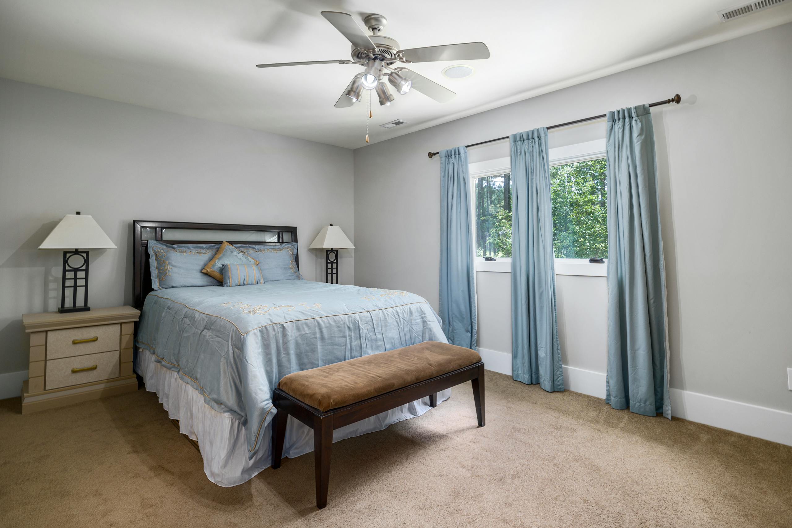 Modern bedroom interior with large bed, natural light, and elegant decor.