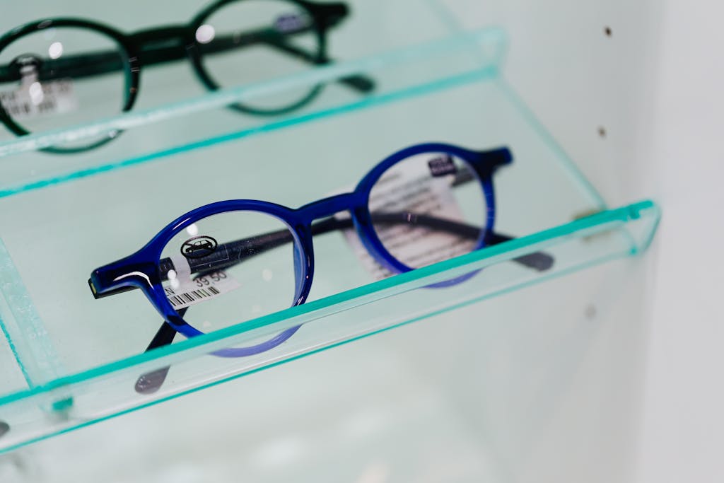 Modern blue eyeglasses showcased in a glass display case, perfect for fashion and optics themes.