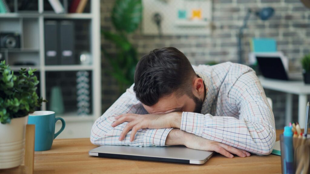 man-in-shirt-lying-down-on-table-at-office