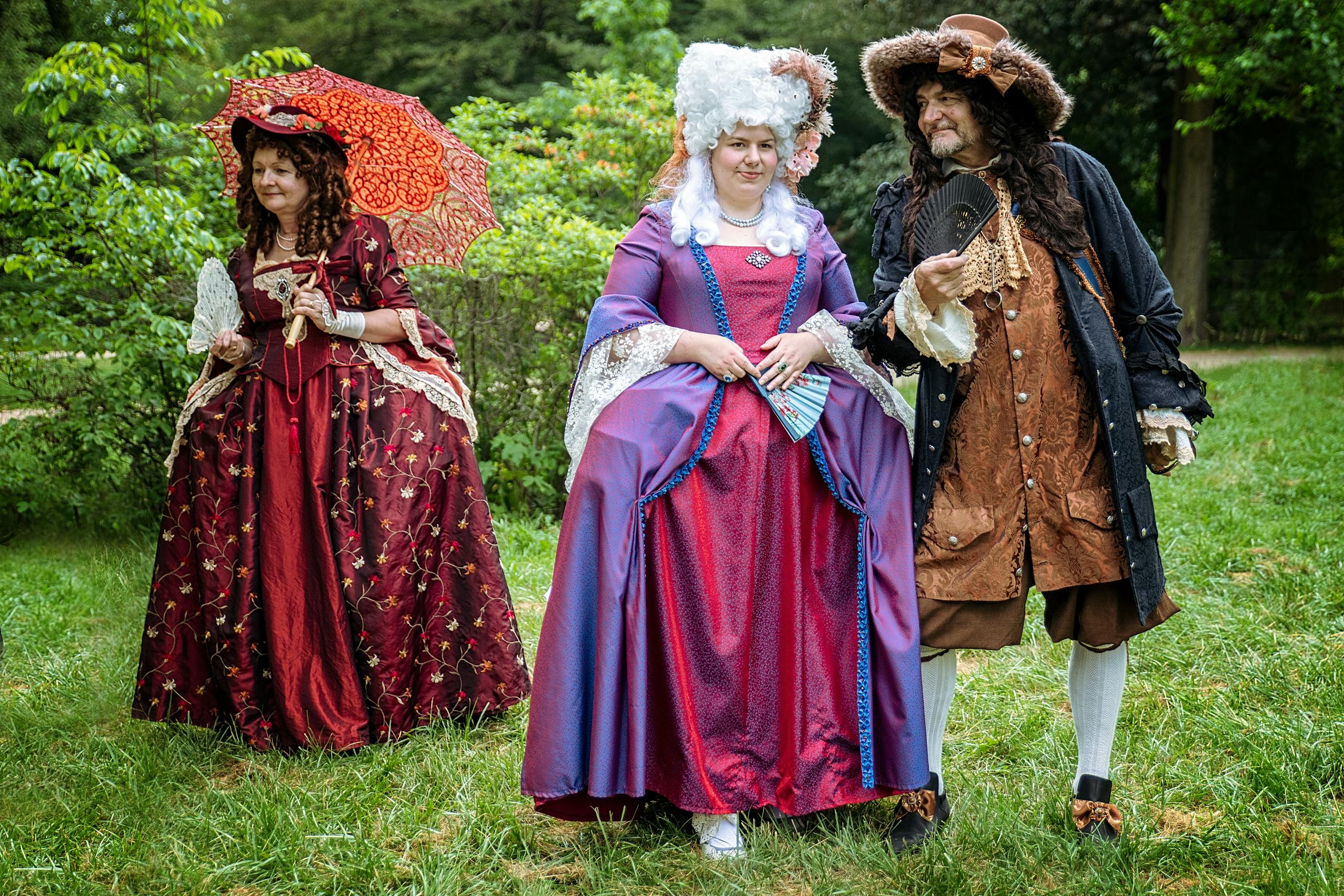 A group dressed in luxurious Baroque fashion enjoys a day outdoors in Leipzig.