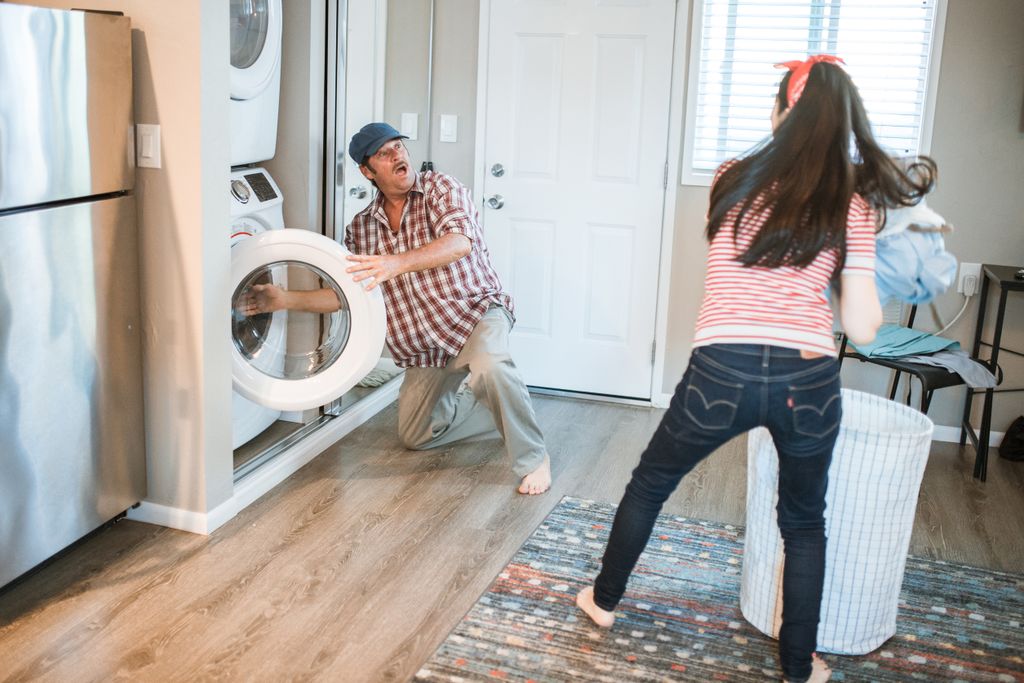 A man and woman doing laundry together in a modern home setting.