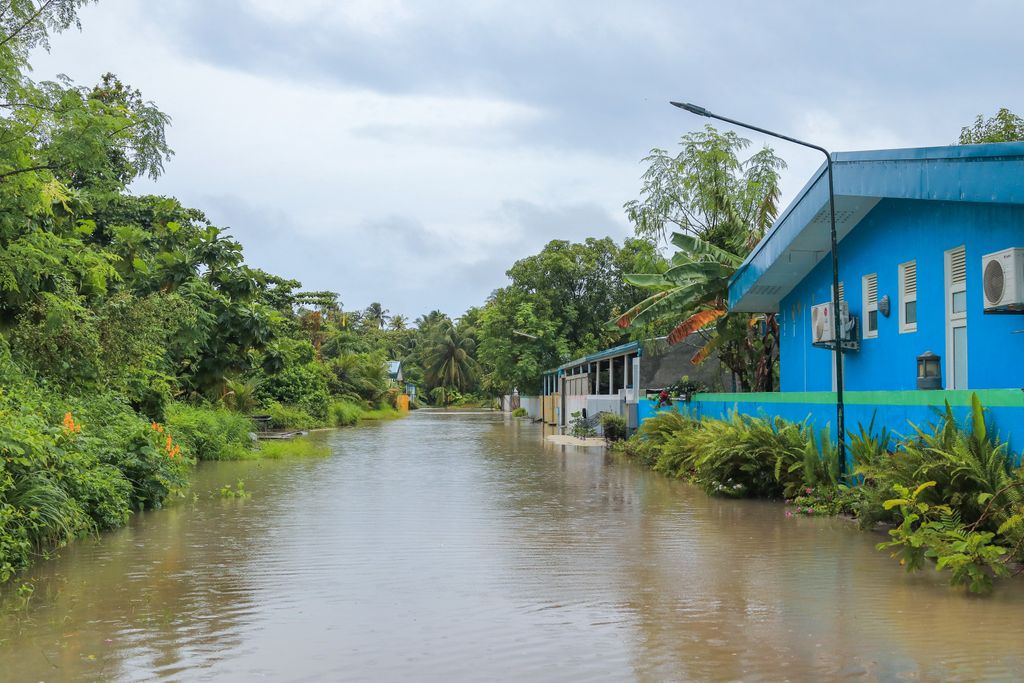 A tropical street in Nolhivaranfaru, Maldives, submerged due to flooding.
