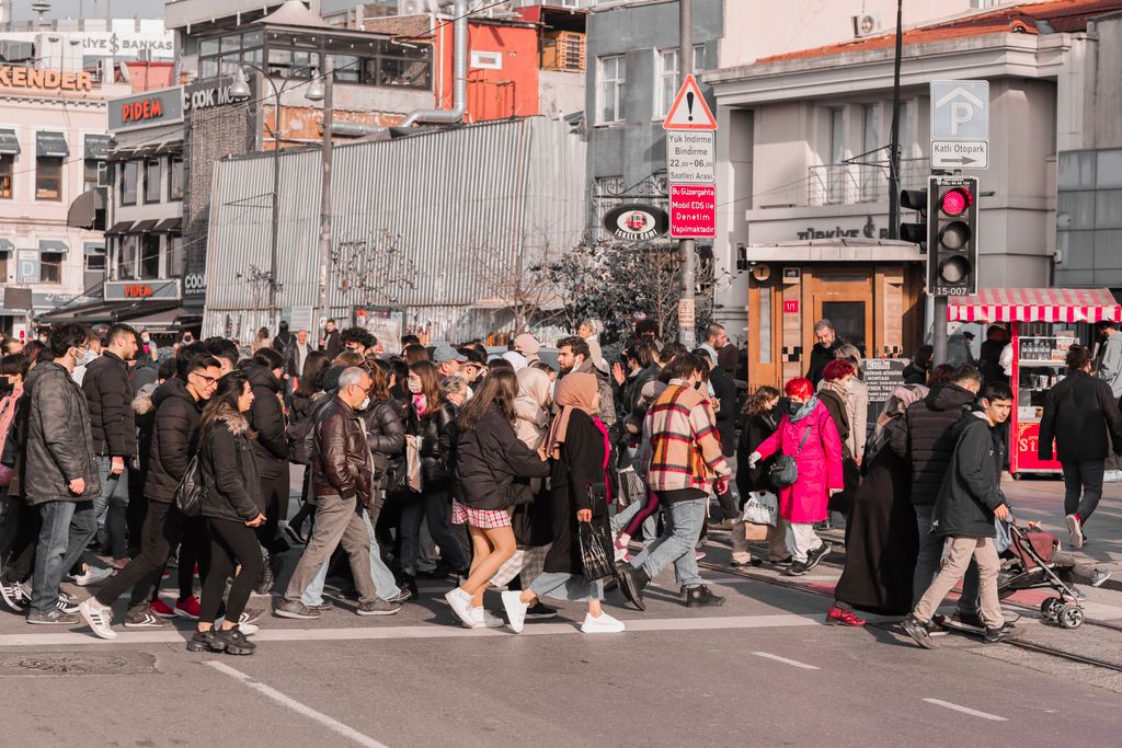 A vibrant and bustling pedestrian crossing in Istanbul, showcasing diverse city life and architecture.
