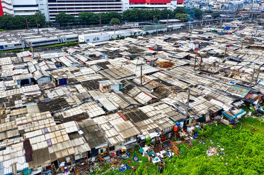 Aerial view of densely packed urban settlements and railway in Jakarta, Indonesia.