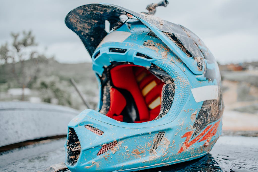 Close-up of a mud-covered motocross helmet outdoors, showcasing adventure and thrill.
