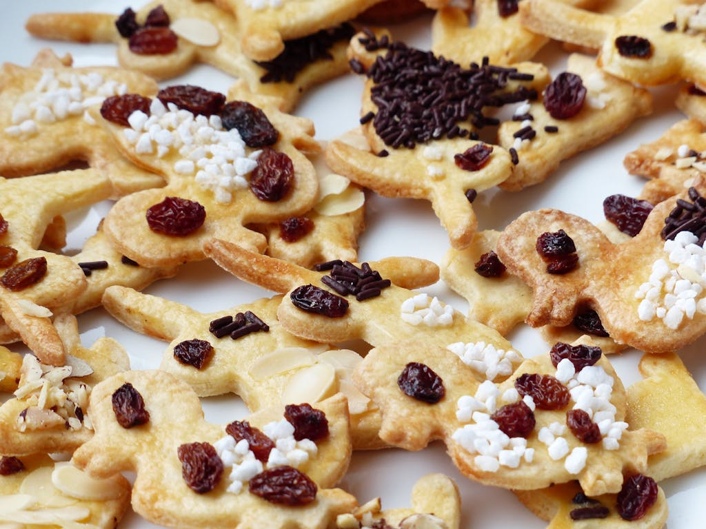 Delicious homemade gingerbread cookies decorated with raisins and sprinkles. Perfect for festive occasions.