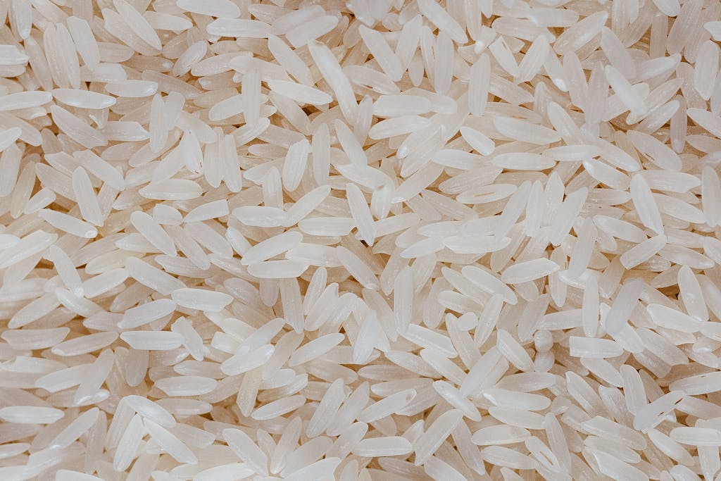 Detailed view of uncooked white rice grains, showcasing texture and pattern.