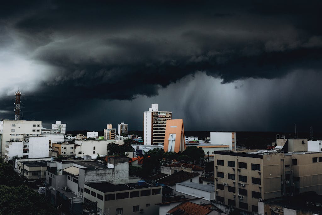 Dramatic storm clouds hover over city skyscrapers, creating a moody urban landscape contrast.