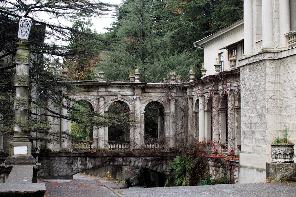 Explore the detailed architecture of an abandoned sanatorium in Sochi, amidst lush greenery.