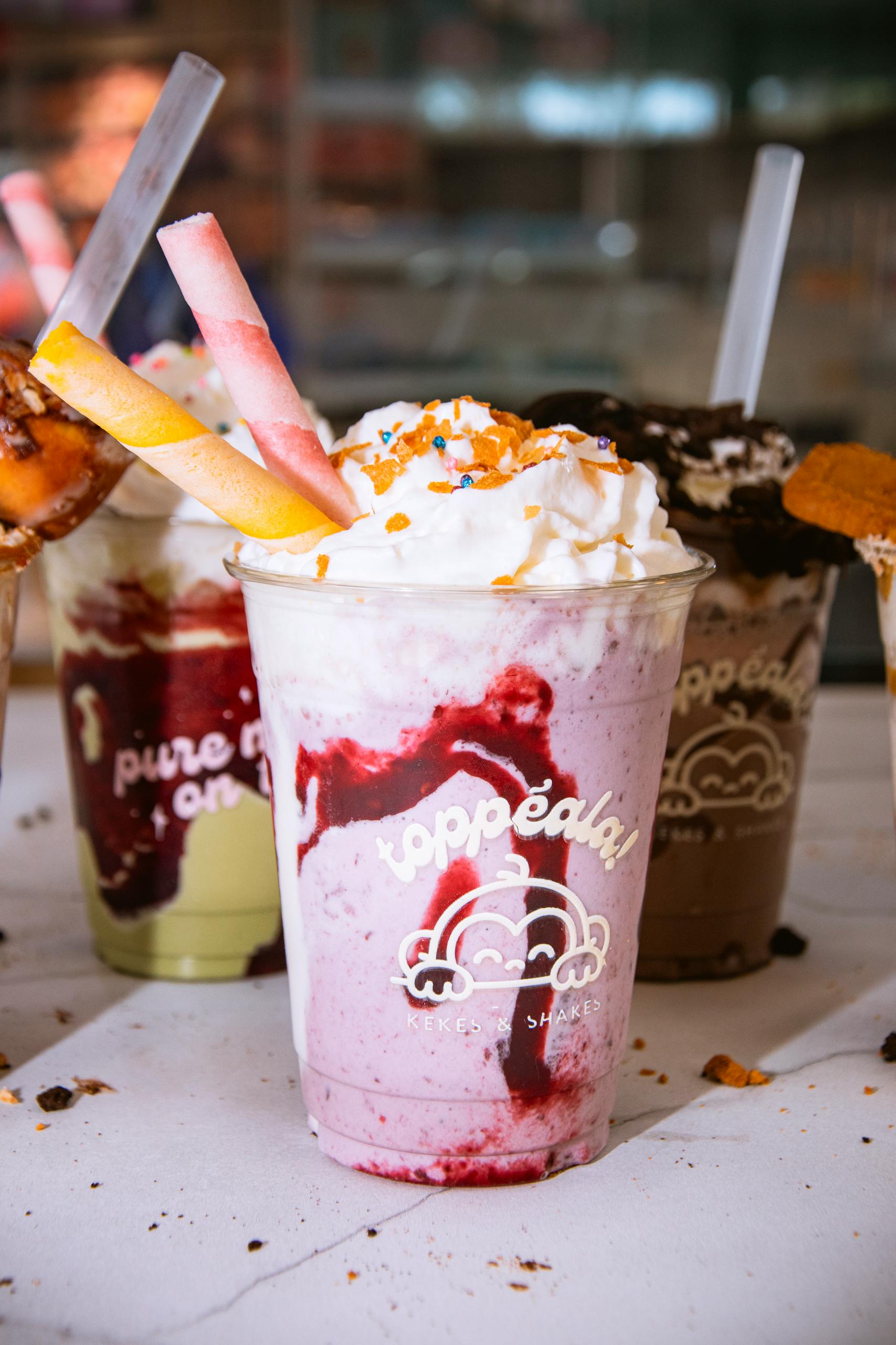 Indulgent milkshakes topped with whipped cream, sprinkles, and wafer sticks. Perfect summer treat.