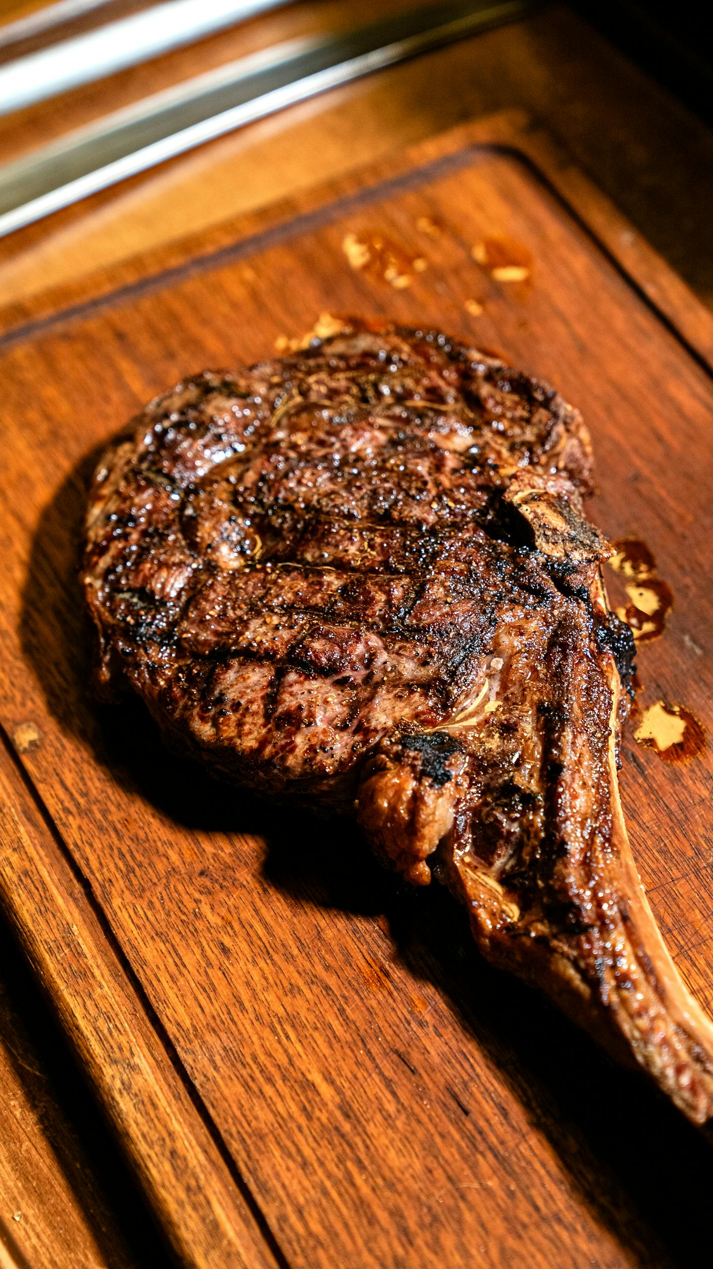 Juicy grilled ribeye steak on a rustic wooden board, perfect for gourmet meal presentations.