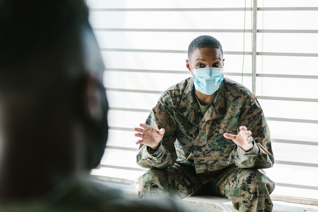 Military personnel in a therapy session, focused on mental health and support.