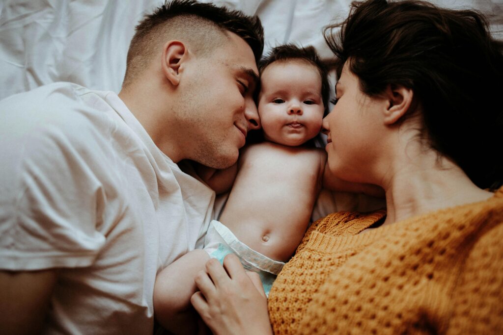 couple-lying-with-baby-between-them