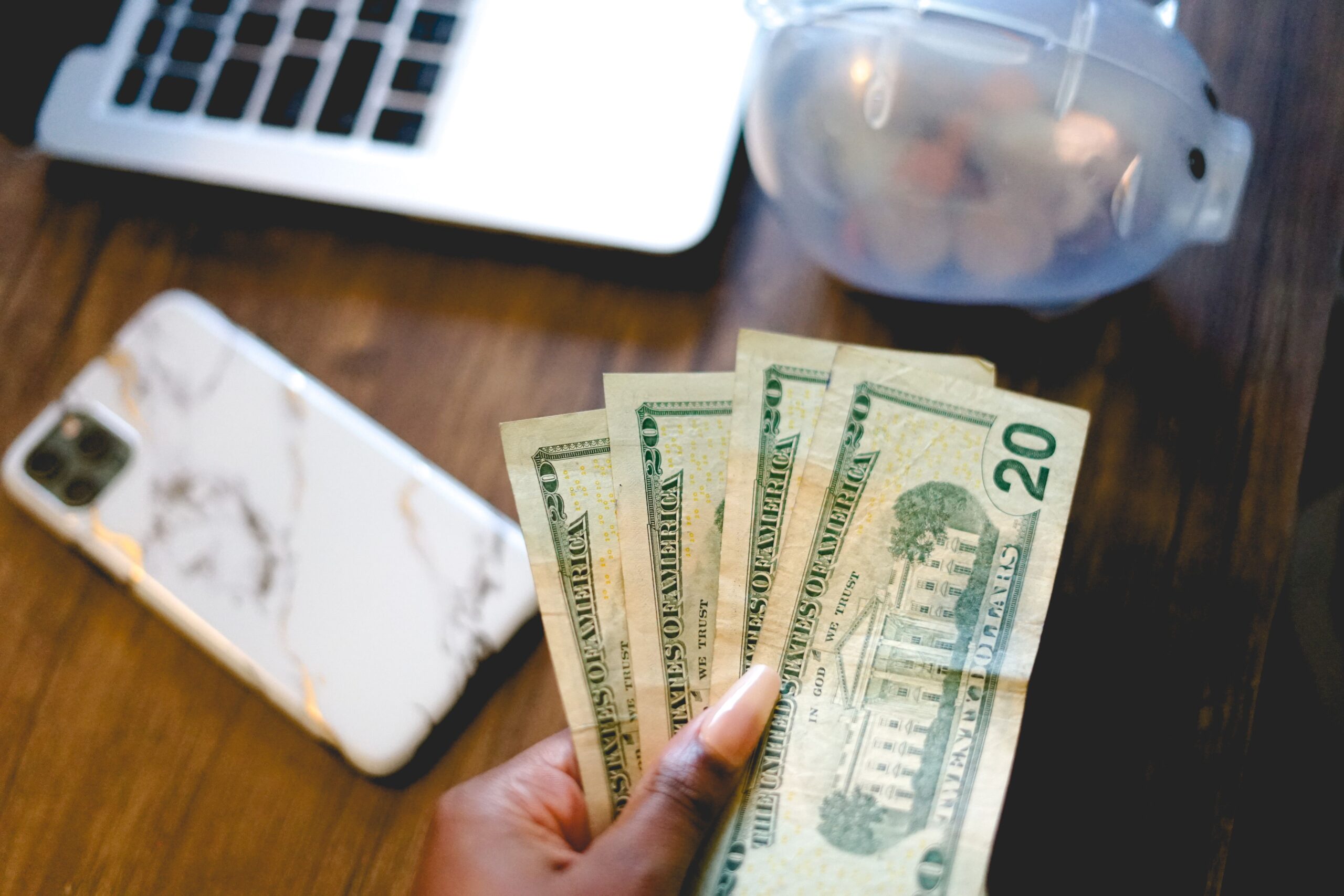 twenty-dollar-bills-on-top-of-a-wooden-desk