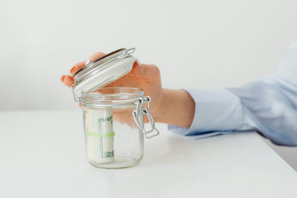 a-person-saving-money-in-the-glass-jar