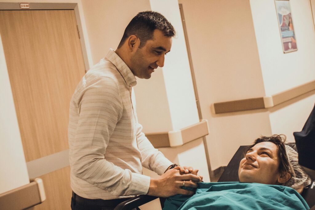 man-comforting-woman-lying-on-bed-in-hospital
