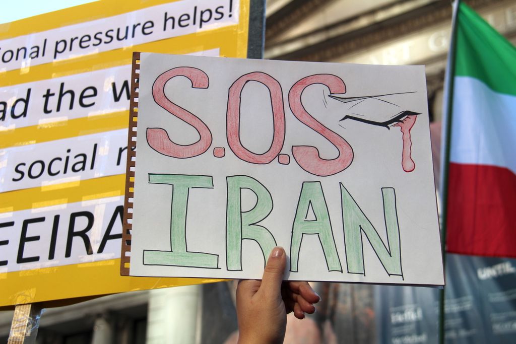 Protest sign reading SOS Iran during a demonstration in Vancouver, raising awareness for Iranian issues.