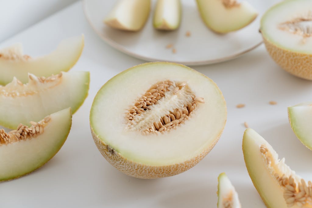 Sliced cantaloupe showcasing fresh seeds on a clean white surface, ideal for healthy eating themes.