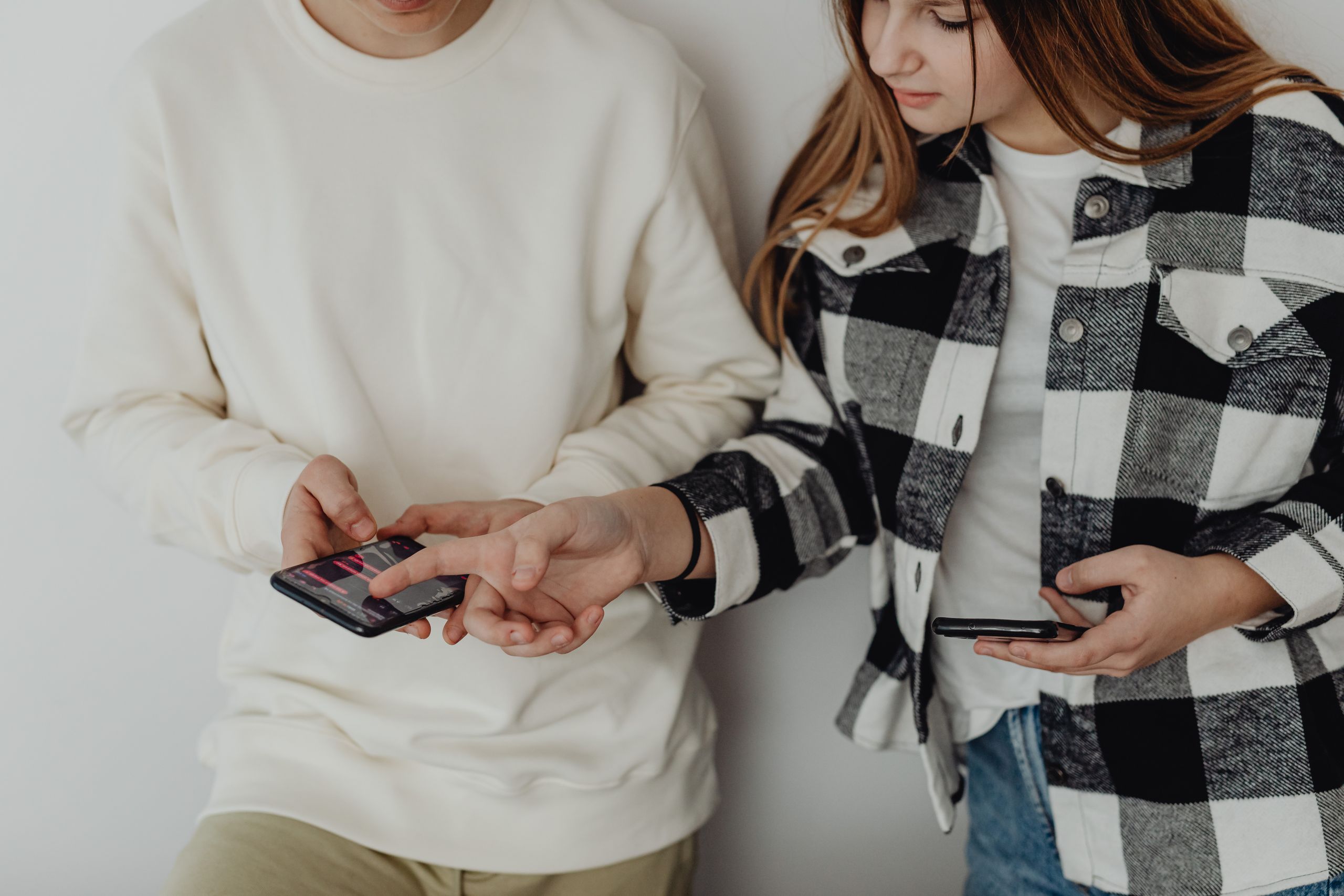 Teenagers interacting with smartphones, sharing content, and discussing technology indoors.
