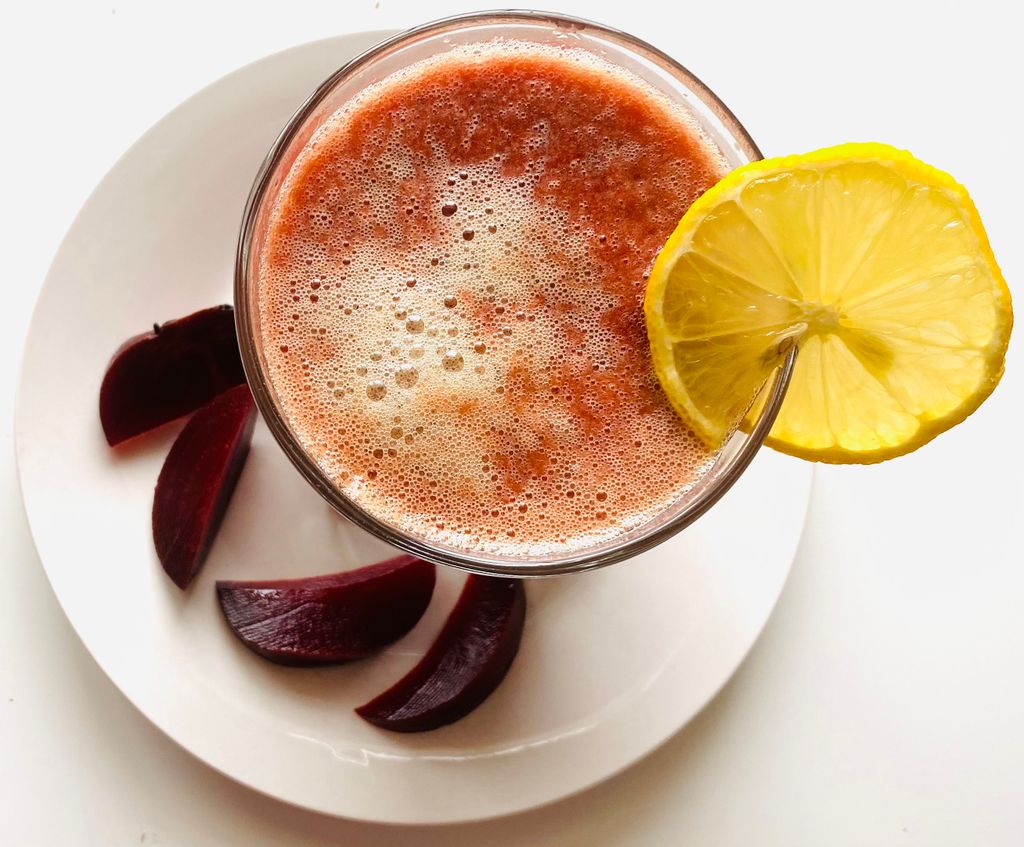 Top view of a vibrant beetroot juice with a lemon garnish, perfect for refreshing health drinks.