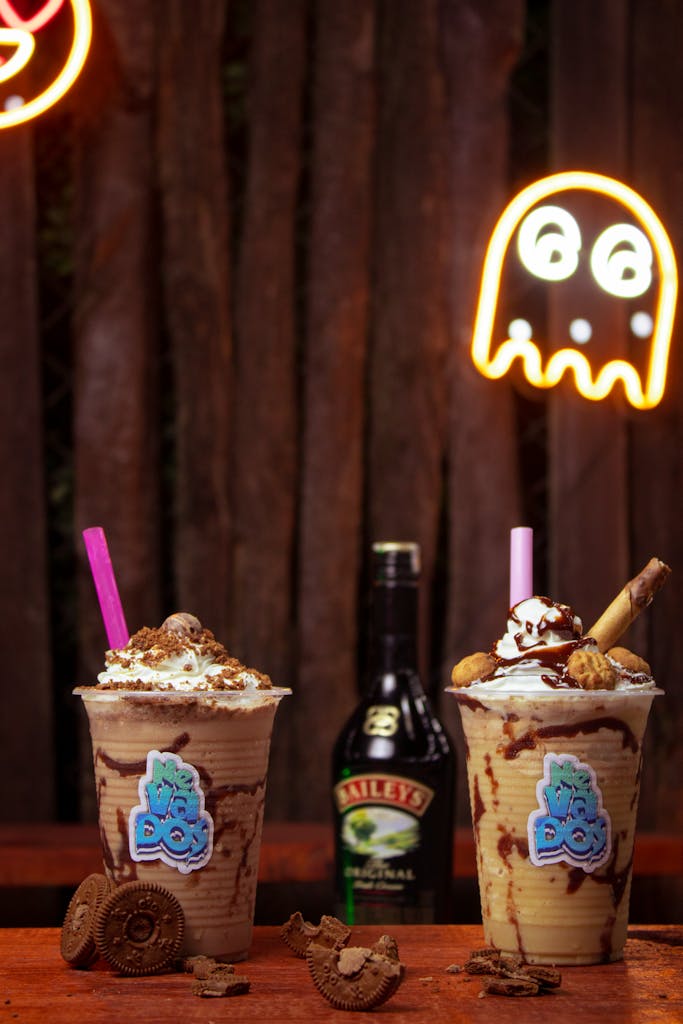 Two creamy chocolate shakes topped with cookies and whipped cream, perfect indulgence.