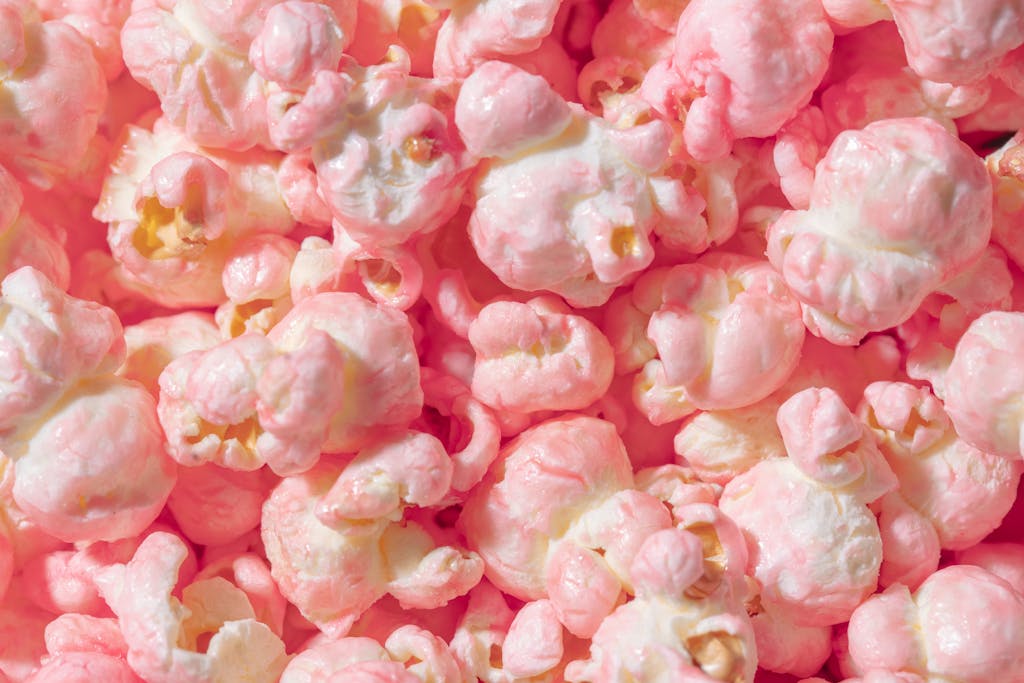 Vibrant close-up of pink candy coated popcorn, perfect for sweet snack themes.