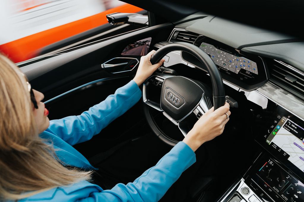 Woman wearing blue blazer driving an Audi in Curitiba, Brazil.
